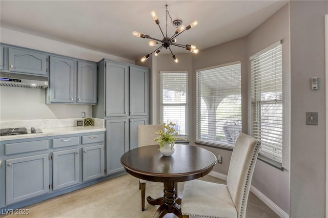 1833 Winners Cup Dr, Las Vegas, NV 89117 - kitchen featuring a chandelier, under cabinet range hood, stainless steel gas stovetop, and plenty of natural light