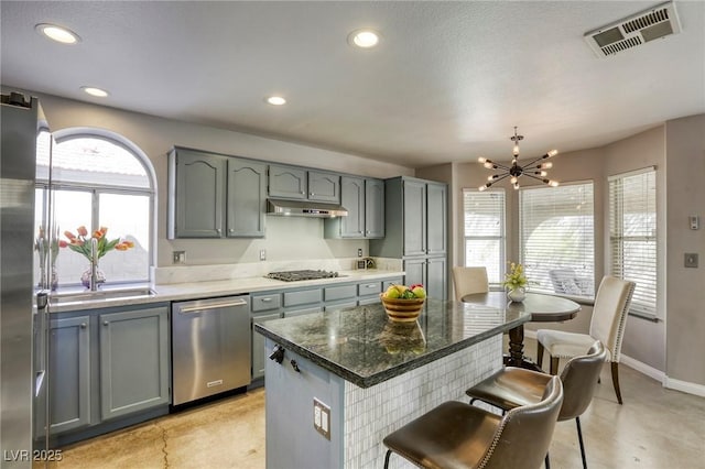 1833 Winners Cup Dr, Las Vegas, NV 89117 - kitchen featuring stainless steel appliances, a chandelier, under cabinet range hood, a kitchen breakfast bar, and recessed lighting