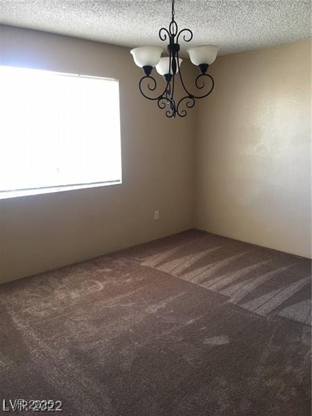 5220 Mission Carmel Ln Unit 207, Las Vegas, NV 89107 - spare room featuring carpet floors, a chandelier, and a textured ceiling