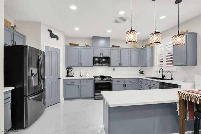 1763 Crystal Stream Ave, Henderson, NV 89012 - kitchen featuring stainless steel appliances, gray cabinets, a peninsula, a sink, and light marble finish floors