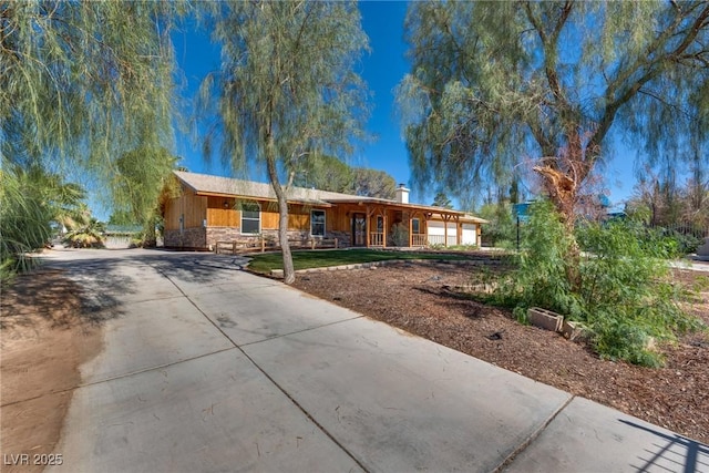 7950 Red Barn Dr, Las Vegas, NV 89123 - ranch-style house with driveway, covered porch, stone siding, and a chimney