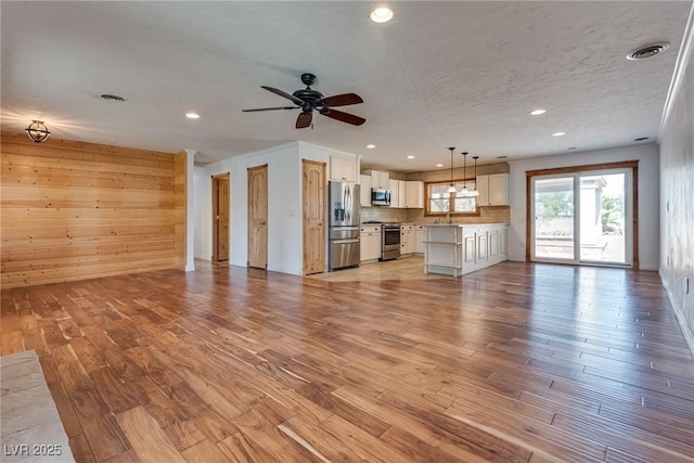 7950 Red Barn Dr, Las Vegas, NV 89123 - unfurnished living room with light wood finished floors, recessed lighting, ceiling fan, a sink, and a textured ceiling