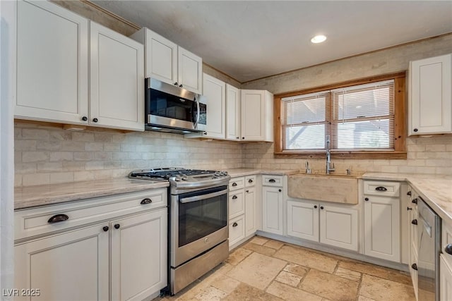 7950 Red Barn Dr, Las Vegas, NV 89123 - kitchen featuring stainless steel appliances, a sink, stone tile floors, backsplash, and white cabinetry