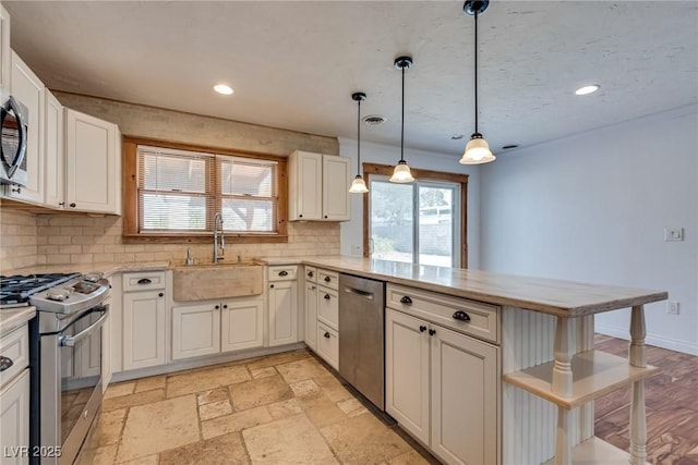 7950 Red Barn Dr, Las Vegas, NV 89123 - kitchen with appliances with stainless steel finishes, a sink, a peninsula, tasteful backsplash, and recessed lighting