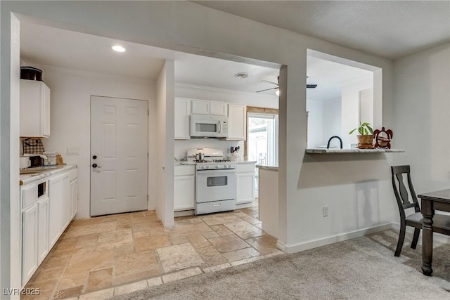7950 Red Barn Dr, Las Vegas, NV 89123 - kitchen with white appliances, white cabinetry, light countertops, ceiling fan, and stone tile flooring