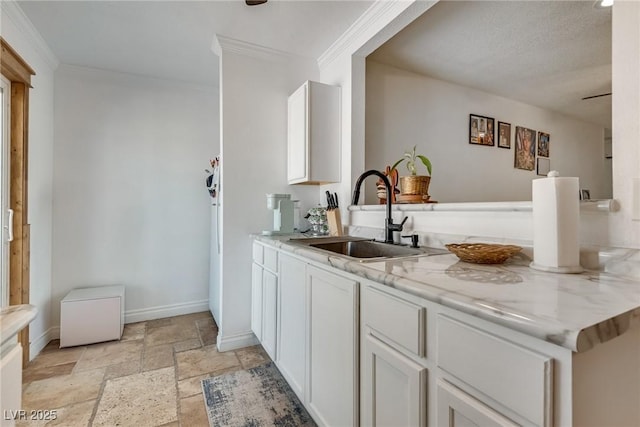 7950 Red Barn Dr, Las Vegas, NV 89123 - kitchen with a sink, baseboards, stone tile flooring, ornamental molding, and white cabinetry