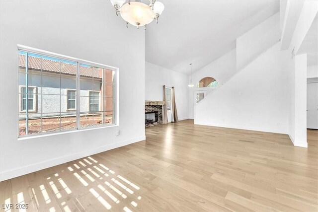 5216 Desert Star Dr, Las Vegas, NV 89130 - unfurnished living room featuring high vaulted ceiling, plenty of natural light, a chandelier, wood finished floors, and baseboards