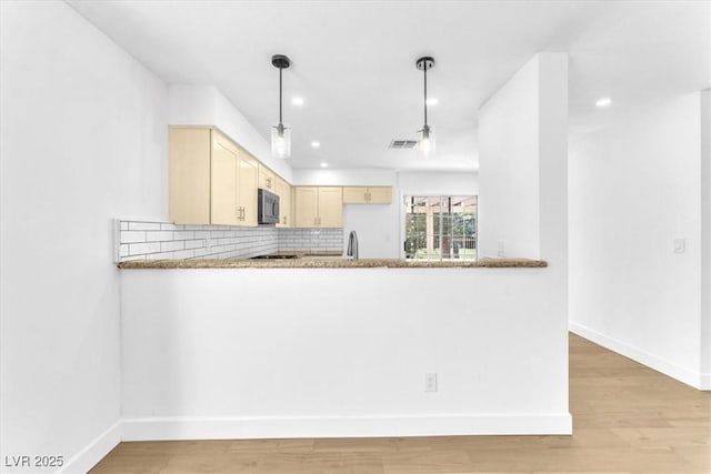 5216 Desert Star Dr, Las Vegas, NV 89130 - kitchen with baseboards, a peninsula, recessed lighting, light wood-style flooring, and tasteful backsplash
