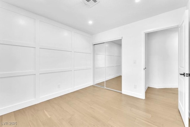 5216 Desert Star Dr, Las Vegas, NV 89130 - unfurnished bedroom with a decorative wall, light wood-type flooring, a closet, recessed lighting, and baseboards