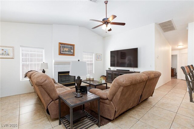 905 White Thunder St, Henderson, NV 89002 - living area featuring light tile patterned flooring, a ceiling fan, a tile fireplace, lofted ceiling, and baseboards