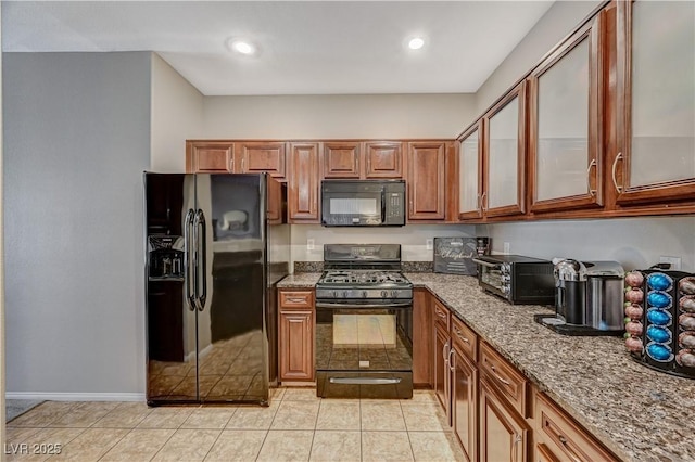 8717 Red Brook Dr Unit 201, Las Vegas, NV 89128 - kitchen featuring black appliances, stone countertops, brown cabinets, glass insert cabinets, and light tile patterned floors