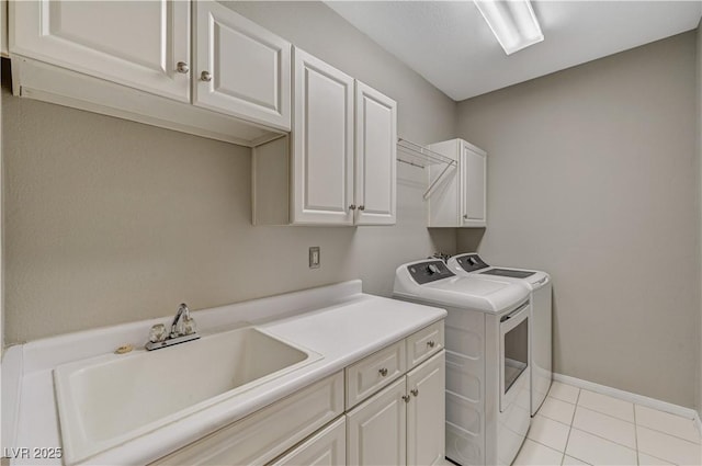 8717 Red Brook Dr Unit 201, Las Vegas, NV 89128 - laundry area featuring cabinet space, separate washer and dryer, light tile patterned floors, and baseboards