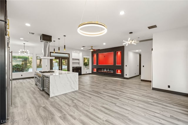 9029 Rivers Edge Dr, Las Vegas, NV 89117 - unfurnished living room featuring baseboards, recessed lighting, a ceiling fan, light wood-style floors, and a chandelier