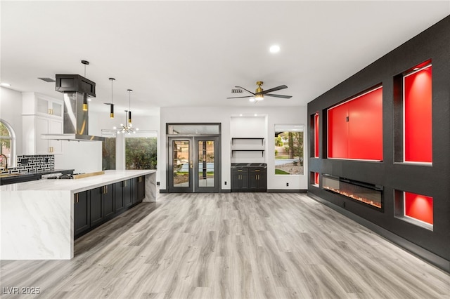 9029 Rivers Edge Dr, Las Vegas, NV 89117 - unfurnished living room with a glass covered fireplace, light wood-style floors, ceiling fan, a chandelier, and recessed lighting