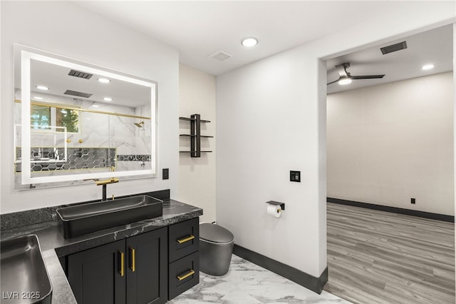 9029 Rivers Edge Dr, Las Vegas, NV 89117 - bathroom with toilet, a ceiling fan, a marble finish shower, vanity, and baseboards