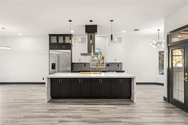 9029 Rivers Edge Dr, Las Vegas, NV 89117 - kitchen with built in refrigerator, exhaust hood, white cabinets, light wood-style floors, and recessed lighting
