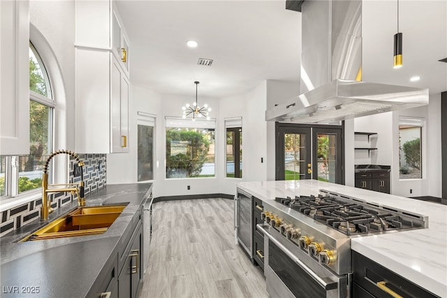 9029 Rivers Edge Dr, Las Vegas, NV 89117 - kitchen featuring stainless steel appliances, island range hood, a sink, white cabinetry, and dark cabinetry