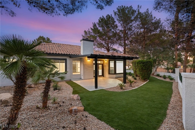 9029 Rivers Edge Dr, Las Vegas, NV 89117 - back of house at dusk featuring a chimney, a patio area, a tiled roof, and stucco siding