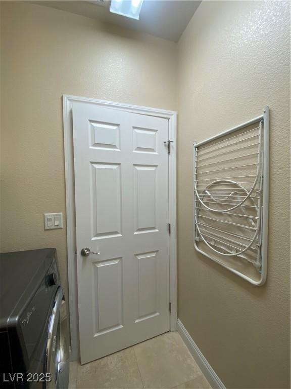 5376 S Conquistador St, Las Vegas, NV 89148 - washroom with washer and clothes dryer, light tile patterned flooring, and baseboards