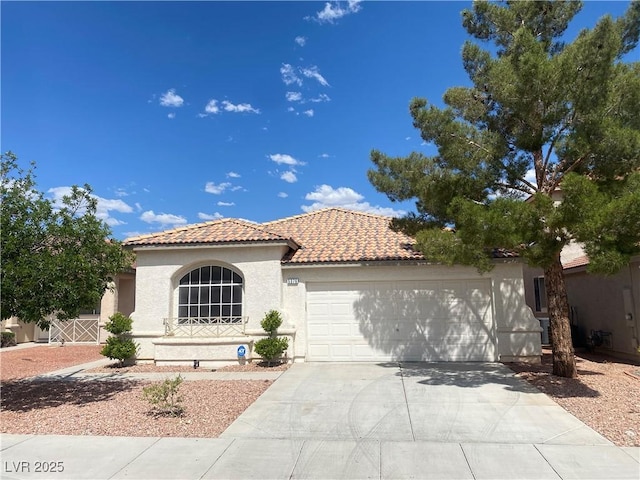 5376 S Conquistador St, Las Vegas, NV 89148 - mediterranean / spanish home featuring a tile roof, a garage, stucco siding, and concrete driveway