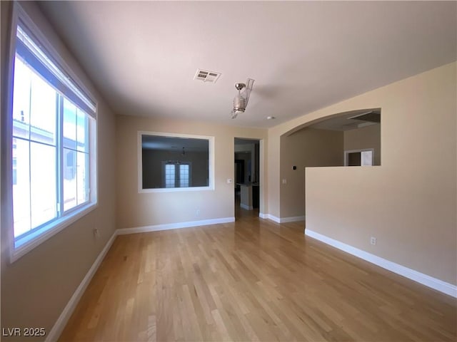 5376 S Conquistador St, Las Vegas, NV 89148 - empty room featuring arched walkways, light wood-style floors, and baseboards