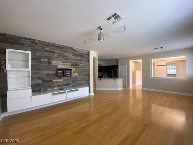 5376 S Conquistador St, Las Vegas, NV 89148 - unfurnished living room with a ceiling fan, light wood-style floors, baseboards, and arched walkways