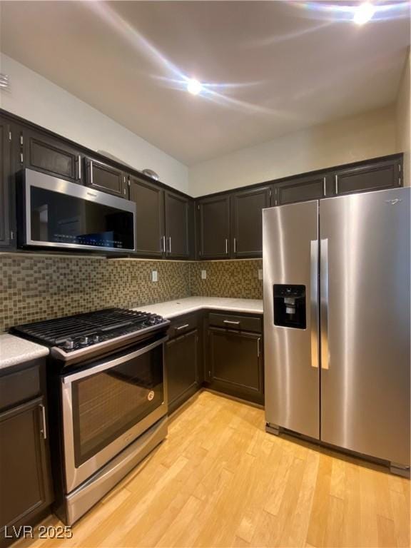 5376 S Conquistador St, Las Vegas, NV 89148 - kitchen with appliances with stainless steel finishes, light countertops, light wood-style flooring, and decorative backsplash