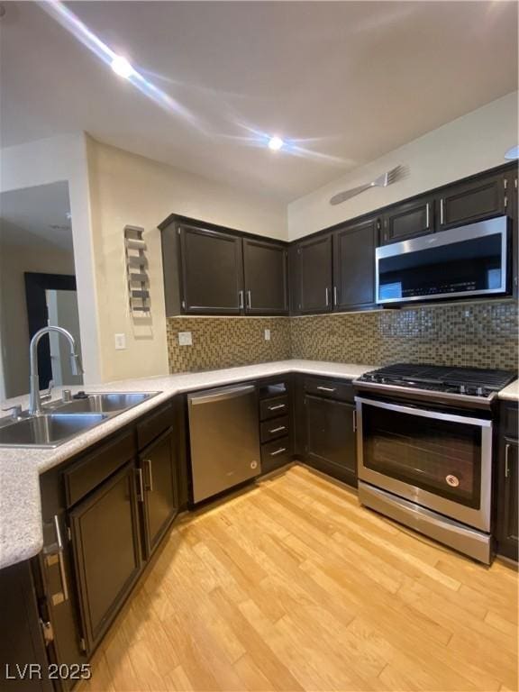 5376 S Conquistador St, Las Vegas, NV 89148 - kitchen with stainless steel appliances, a sink, light countertops, and light wood-style flooring