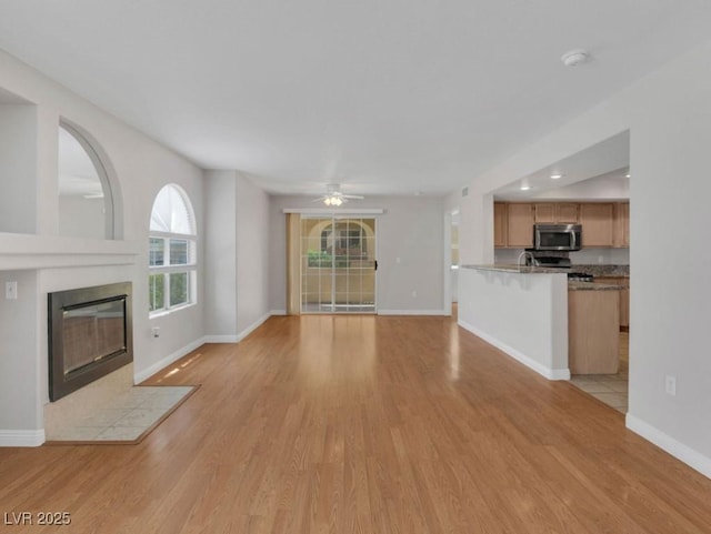 7950 W Flamingo Rd Unit 1077, Las Vegas, NV 89147 - unfurnished living room featuring a fireplace, light wood finished floors, baseboards, a ceiling fan, and recessed lighting