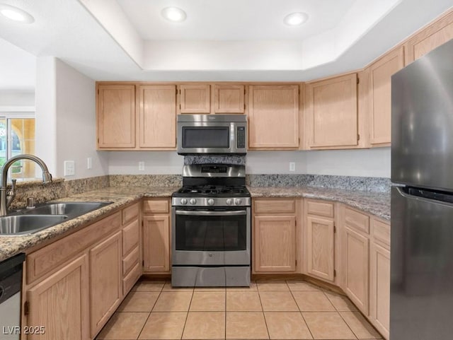 7950 W Flamingo Rd Unit 1077, Las Vegas, NV 89147 - kitchen featuring stainless steel appliances, a sink, light brown cabinetry, light tile patterned floors, and a tray ceiling