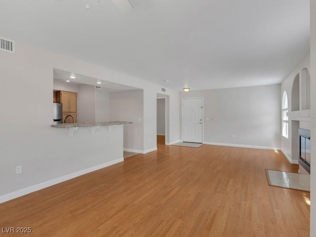 7950 W Flamingo Rd Unit 1077, Las Vegas, NV 89147 - unfurnished living room featuring light wood-style floors, baseboards, and a fireplace with flush hearth