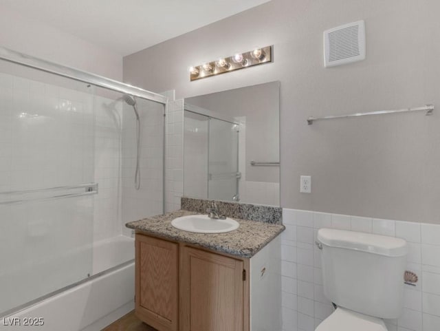 7950 W Flamingo Rd Unit 1077, Las Vegas, NV 89147 - bathroom with vanity, bath / shower combo with glass door, toilet, and wainscoting