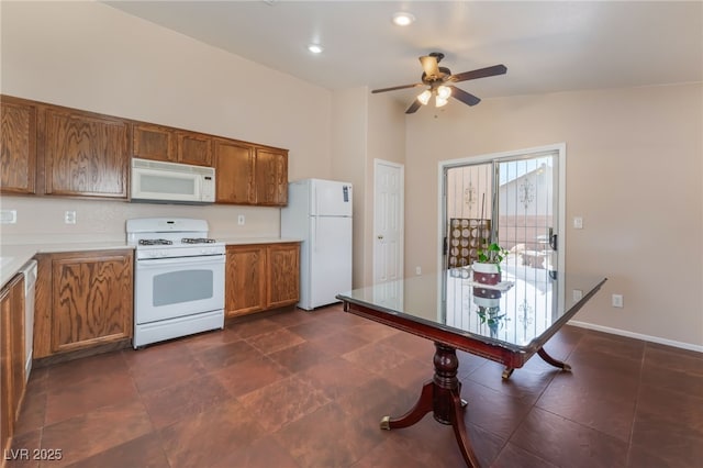 2825 Shayla Bay Ave, North Las Vegas, NV 89086 - kitchen with white appliances, brown cabinets, a ceiling fan, vaulted ceiling, and light countertops
