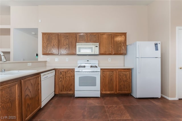 2825 Shayla Bay Ave, North Las Vegas, NV 89086 - kitchen with white appliances, brown cabinetry, light countertops, and a sink