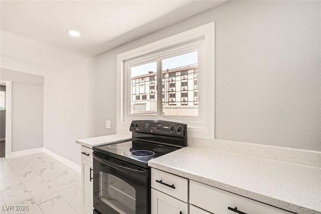4558 Sheppard Dr, Las Vegas, NV 89122 - kitchen featuring black range with electric cooktop, light marble finish floors, white cabinetry, light stone counters, and baseboards