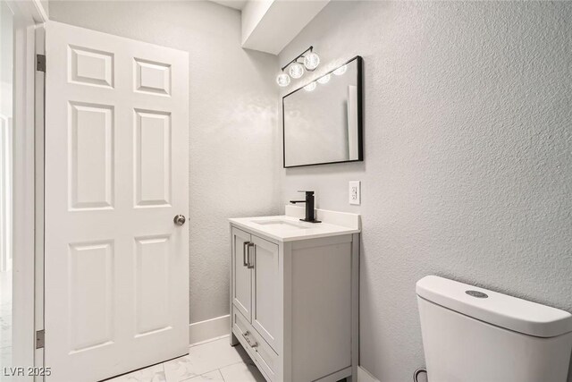 4558 Sheppard Dr, Las Vegas, NV 89122 - bathroom featuring marble look tile flooring, vanity, toilet, and a textured wall