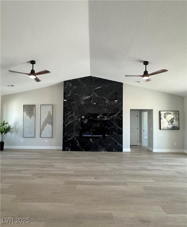3791 Soplo Rd, Pahrump, NV 89048 - unfurnished living room featuring ceiling fan, lofted ceiling, baseboards, wood finished floors, and a textured ceiling