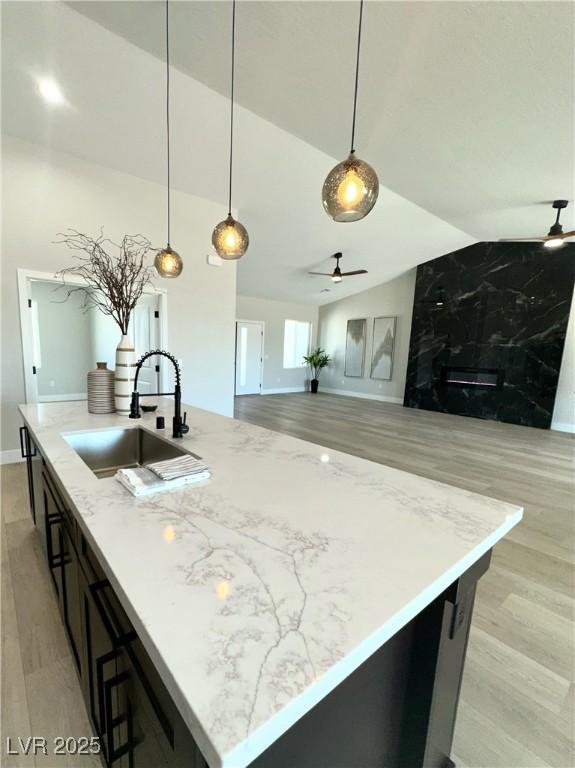 3791 Soplo Rd, Pahrump, NV 89048 - kitchen featuring a sink, a ceiling fan, light wood-style floors, lofted ceiling, and hanging light fixtures