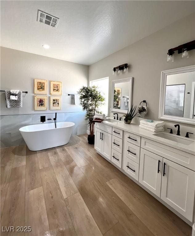 3791 Soplo Rd, Pahrump, NV 89048 - bathroom featuring double vanity, wood finished floors, and a freestanding tub