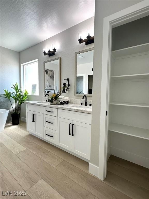 3791 Soplo Rd, Pahrump, NV 89048 - full bathroom featuring wood finished floors, double vanity, and a soaking tub