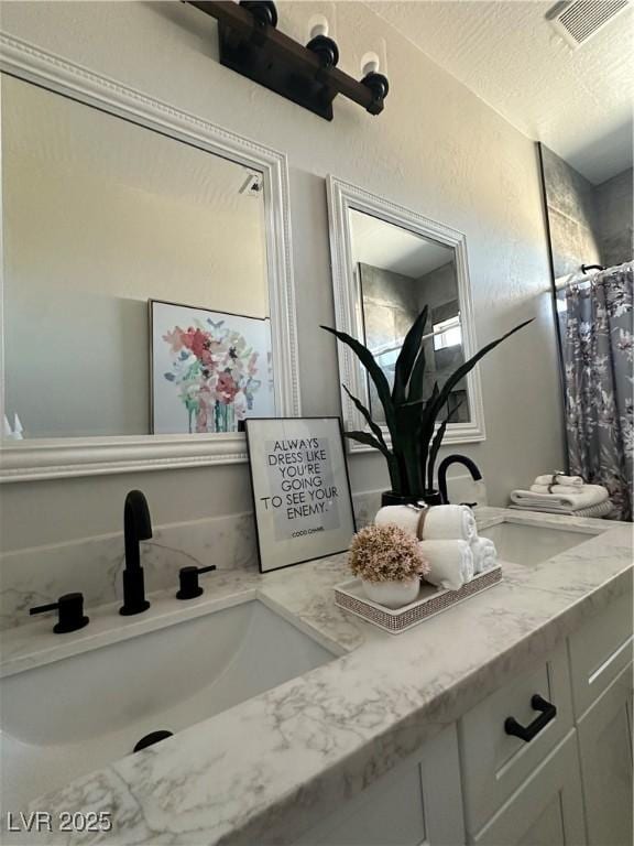 3791 Soplo Rd, Pahrump, NV 89048 - bathroom featuring double vanity, a shower with curtain, and a textured ceiling