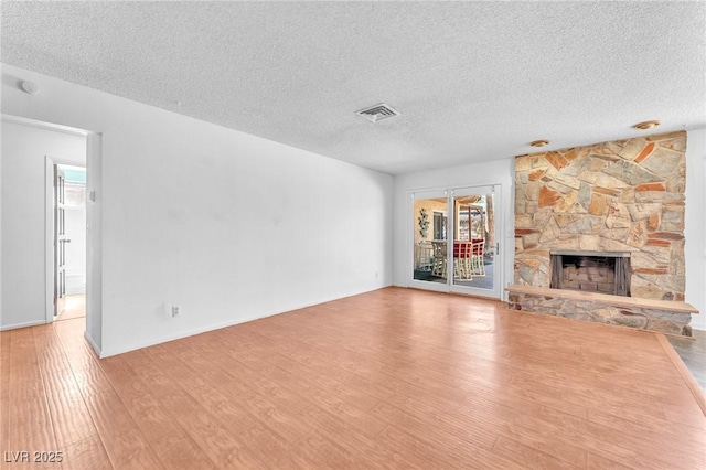 3158 La Luna Cir, Henderson, NV 89014 - unfurnished living room with healthy amount of natural light, wood finished floors, a textured ceiling, and a stone fireplace