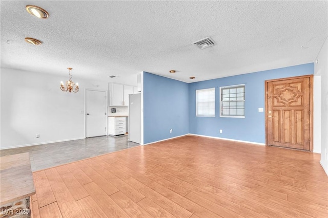 3158 La Luna Cir, Henderson, NV 89014 - unfurnished living room with a chandelier, light wood-type flooring, and a textured ceiling