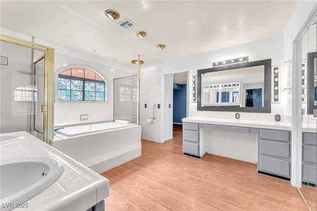 3158 La Luna Cir, Henderson, NV 89014 - bathroom featuring double vanity, a bath, wood finished floors, and a stall shower