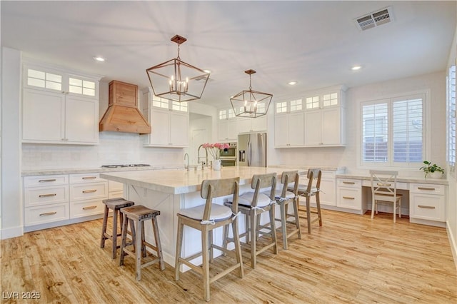5434 Fawn Chase Way, Las Vegas, NV 89135 - kitchen with premium range hood, stainless steel refrigerator with ice dispenser, gas cooktop, light wood-style flooring, and recessed lighting