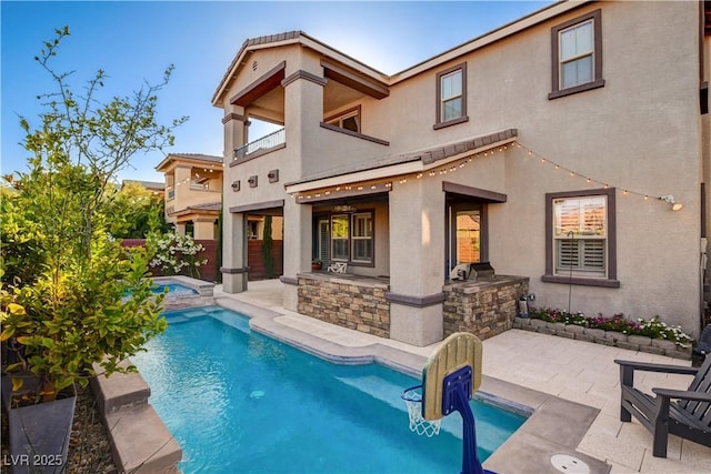 5434 Fawn Chase Way, Las Vegas, NV 89135 - back of house with area for grilling, stucco siding, a patio area, a pool with connected hot tub, and a balcony