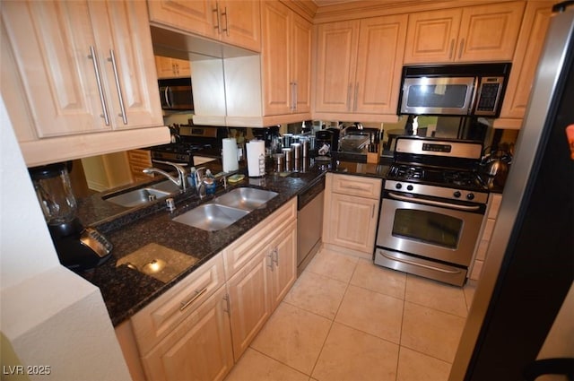230 E Flamingo Rd Unit 129, Las Vegas, NV 89169 - kitchen with stainless steel appliances, a sink, light tile patterned floors, and dark stone counters
