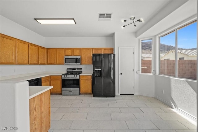 10642 Dawns Mist Ave, Las Vegas, NV 89129 - kitchen with black appliances, brown cabinetry, and light countertops