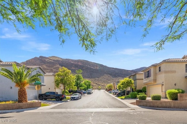 10642 Dawns Mist Ave, Las Vegas, NV 89129 - view of asphalt road featuring a mountain view, sidewalks, curbs, and a residential view