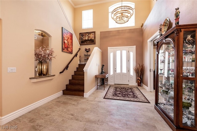 7718 Willow Cove Cir, Las Vegas, NV 89129 - entrance foyer with crown molding, baseboards, stairway, a high ceiling, and a chandelier
